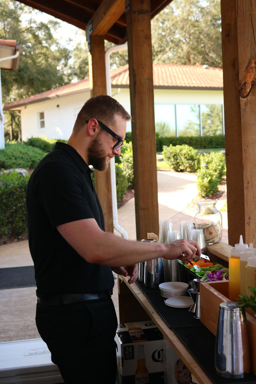 Los Primos bartender preparing drinks at an outdoor event bar